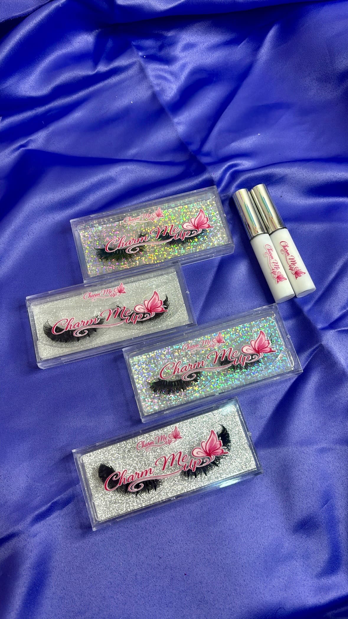CharmeUp lash boxes arranged in holographic and silver glitter colorways